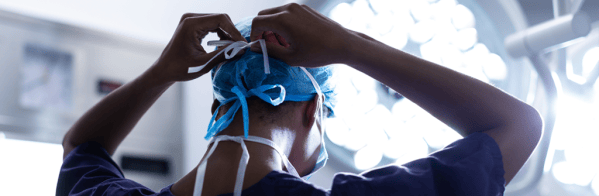 Picture of someone putting on a facemask in an operating theatre