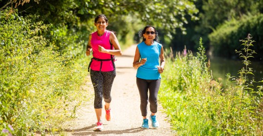 Two women running in a park.
