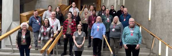 Photo of the participants of the People’s Panel reviewing the Climate Change (Scotland) Act 2009. The participants are standing on the stairs in the Scottish Parliament building.