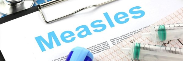 A clipboard that says Measles, surrounded by medical equipment.