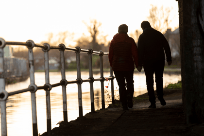 Picture of two people walking by river